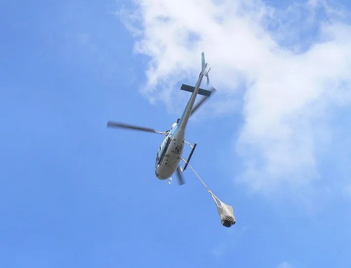 Elicottero in volo con carico sospeso per trasporto materiali