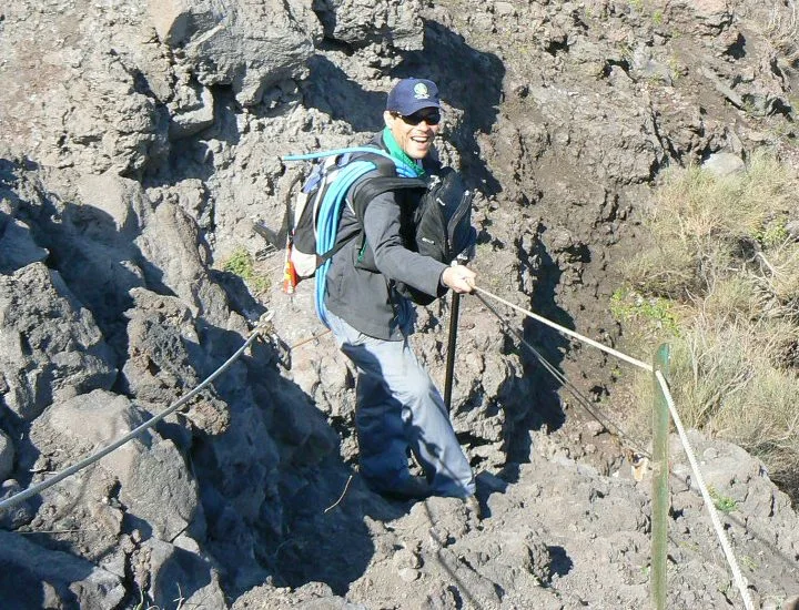 Tecnico su sentiero attrezzato con corde fisse su roccia vulcanica